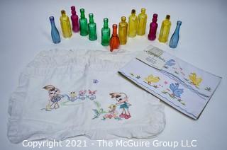 Selection of Small Colored Glass Reproduction Bottles and Embroidered Baby Linens 