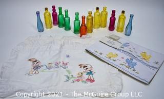 Selection of Small Colored Glass Reproduction Bottles and Embroidered Baby Linens 