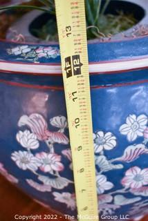 Large Asian Hand Painted on Blue Ground Porcelain Fish Bowl Planter with Faux Plant. Measures 12" Tall  x 14" Diameter.