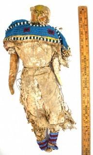 19th Century Prairie, Plains and Plateau Native American Doll, Possibly Sioux, Made of Hide and Flour Bag Muslin with Beaded Yoke.  Fabric and hide loss.  Measures 22" long. 