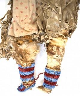 19th Century Prairie, Plains and Plateau Native American Doll, Possibly Sioux, Made of Hide and Flour Bag Muslin with Beaded Yoke.  Fabric and hide loss.  Measures 22" long. 