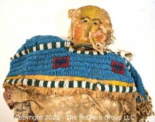 19th Century Prairie, Plains and Plateau Native American Doll, Possibly Sioux, Made of Hide and Flour Bag Muslin with Beaded Yoke.  Fabric and hide loss.  Measures 22" long. 