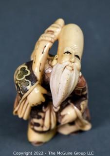 Quality Japanese Netsuke carving of one of the Seven Lucky Gods; Fukurokuju (福禄寿), who is famous for his elongated head, the immense store of wisdom he keeps in it, and his extremely old age. Fukurokuju's name is an amalgam of fuku, meaning 'happiness', roku, meaning 'wealth', and ju, which means 'longevity. Poly-chromatic colors. Signed. Composition unknown.