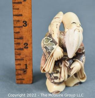 Quality Japanese Netsuke carving of one of the Seven Lucky Gods; Fukurokuju (福禄寿), who is famous for his elongated head, the immense store of wisdom he keeps in it, and his extremely old age. Fukurokuju's name is an amalgam of fuku, meaning 'happiness', roku, meaning 'wealth', and ju, which means 'longevity. Poly-chromatic colors. Signed. Composition unknown.