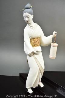 Vintage Porcelain Hand Painted White Porcelain Geisha Descending Stairs with Lantern Figurine in Glass Case with Stepped Base.  Geisha measures 16" tall.  Case measures 14" deep, 22" tall and 29" long.  Fingers have been repaired.