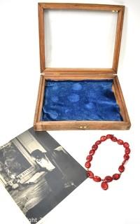 Vintge Wood with Glass Top Case, Red Agate Sone Necklace and Man Reading with War Bonds in Background. 