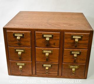 9 Drawer Oak Card Catalog filing case with watch repair contents (jewels, plates, staffs, pinoins and springs, etc.).  See all photos in the photo gallery.  Measures 20W x 17D x 13"T