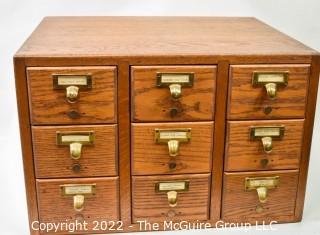 9 Drawer Oak Card Catalog filing case with watch repair contents (jewels, plates, staffs, pinoins and springs, etc.).  See all photos in the photo gallery.  Measures 20W x 17D x 13"T