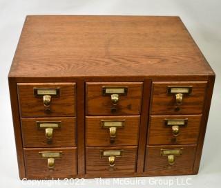 9 Drawer Oak Card Catalog filing case with watch repair contents (jewels, plates, staffs, pinoins and springs, etc.).  See all photos in the photo gallery.  Measures 20W x 17D x 13"T