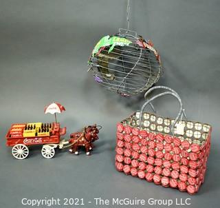 Three Decorative Items Including Coca - Cola Cast Iron Delivery Wagon With Driver, Horses and Crates, Tote Made of Bottle Caps & Wire Folk Art World Globe.