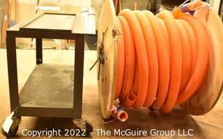 Approximately 58' Orange Hose on Wooden Reel and small metal two shelf cart on casters. 