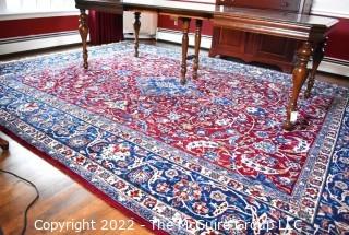 Vintage Isfahan Signed Hand-Knotted Wool Rug with Lotus Blossom Design on Red Ground with Blue Border. Signed by Artist on Border Edge. Some wear in the center. 118" x 159".