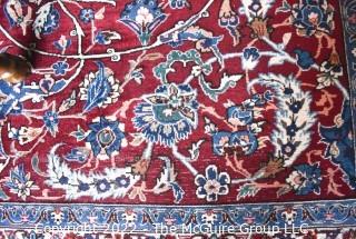 Vintage Isfahan Signed Hand-Knotted Wool Rug with Lotus Blossom Design on Red Ground with Blue Border. Signed by Artist on Border Edge. Some wear in the center. 118" x 159".