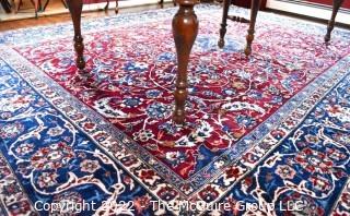 Vintage Isfahan Signed Hand-Knotted Wool Rug with Lotus Blossom Design on Red Ground with Blue Border. Signed by Artist on Border Edge. Some wear in the center. 118" x 159".