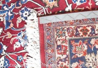 Vintage Isfahan Signed Hand-Knotted Wool Rug with Lotus Blossom Design on Red Ground with Blue Border. Signed by Artist on Border Edge. Some wear in the center. 118" x 159".