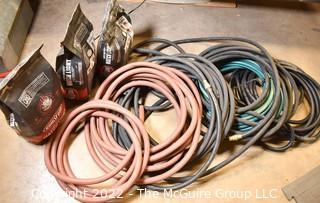 Assortment of Garden Hoses and 3 Bags of Charcoal