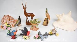 Collection of Decorative Collectibles Including Conch Shells and Porcelain Birds.