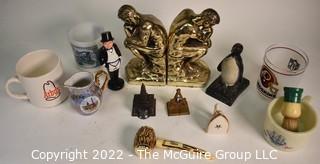 Group of Brass Thinker Bookends, Penquin Coin Bank, Souvenir items and Promotional Mugs.