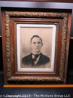 Studio photograph of a young man in antique wooden art frame 