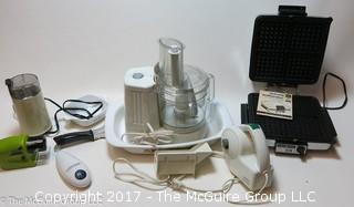 Assorted kitchen appliances including food processor, waffle iron, coffee grinder, can opener and knife sharpeners 