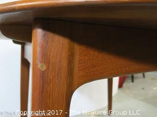 Danish M-C Modern teak dining table and matching chairs (5 side; 1 arm) ; table expands; with leaves stored on the underside, as shown; 45"D x 28 1/2" T