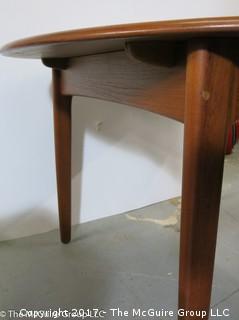 Danish M-C Modern teak dining table and matching chairs (5 side; 1 arm) ; table expands; with leaves stored on the underside, as shown; 45"D x 28 1/2" T