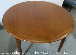 Danish M-C Modern teak dining table and matching chairs (5 side; 1 arm) ; table expands; with leaves stored on the underside, as shown; 45"D x 28 1/2" T