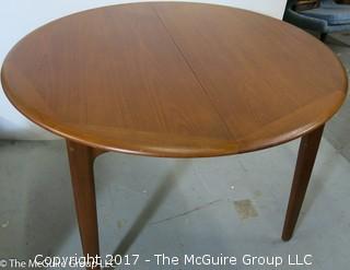 Danish M-C Modern teak dining table and matching chairs (5 side; 1 arm) ; table expands; with leaves stored on the underside, as shown; 45"D x 28 1/2" T