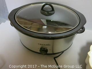 Assorted kitchenware including Crock-POt, Wilton baking molds, collander, paper roll holder and aluminum ice bucket