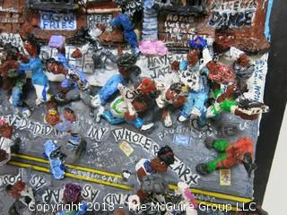 Willie Mays signed montage by Diane Marie Cobert Brunner; depicts street scene in Harlem where Mays was a popular figure participating in local stickball games, where it was said that in the urban game of hitting a rubber ball with an adapted broomstick handle, Mays could hit a shot "six sewers" (6 consecutive New York City manhole covers, nearly 300 feet).  A note card (lower right) says: "In 1950 when the Giants signed me, they gave me $15,000.  I bought a 1950 Mercury.  I couldn't drive, but I had it in the parking lot there, and everybody that could drive would drive the car, so it was like a community "thing" - Willie Mays"  

The artist has exhibited her works at the Empire State Building, the Museum of Contemporary Art in San Diego, the Yogi Berra Museum in New Jersey and the Museum of the Living Artist in San Diego. 21 1/2"W x 26 1/2"T x 7 1/2"D {comes with custom made clear plexiglass cover} Description altered Dec. 6 at 9:54am ET