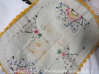 Collection of textiles including needlework tableclothes, napkins, doilies