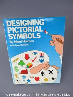 Book Title: "Designing Pictorial Symbols"; authored by Nigel Holmes with Rose DeNeve; published by Watson-Guptill; 1985