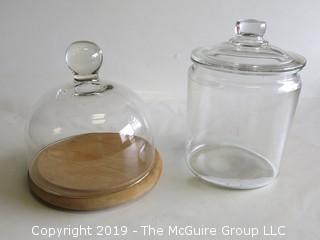 (1) covered clear glass canister and one covered cheese board