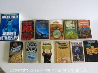 Collection of books including including authors Robert A. Heinlein, Arthur C. Clarke, Douglas Adams, Kurt Vonnegut Jr., and Aldous Huxley 