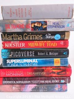 Collection of books including authors Neal Stephenson, Martha Grimes, Arthur Koestler, Robert A. Metzger, Vonda McIntyre, Karen Marie Moning and Stephen R. Donaldson