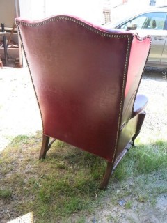 Red Leather Wing Back Chair (Note: needs some re-stitching; bottom wooden stretcher has been re-glued)