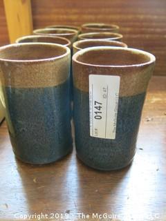 Set of (8) hand thrown glazed pottery cups; signed on base 