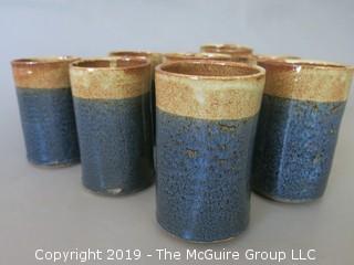 Set of (8) hand thrown glazed pottery cups; signed on base 