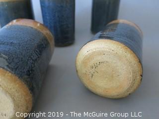 Set of (8) hand thrown glazed pottery cups; signed on base 