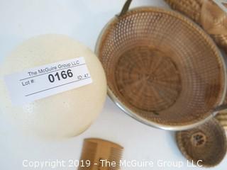 Collection including baskets, wooden combs, an ostrich egg and a handmade paper book.