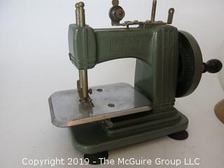 Collection including an oversized wooden yo-yo, a vintage savings bank, and a miniature "Betsy Ross" sewing machine