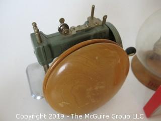 Collection including an oversized wooden yo-yo, a vintage savings bank, and a miniature "Betsy Ross" sewing machine