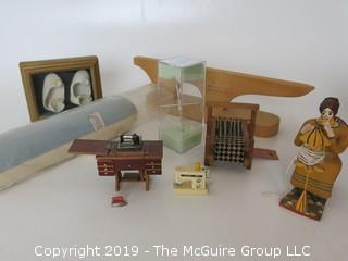 Collection including miniature houndstooth loom, sewing table and woven baby footies in shadow box