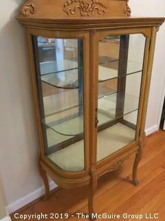 Wooden vitrine with glass panel door, curved glass sides, two glass shelves, mirrored back, raised on shaped legs; 36W x 14D x 58"Tall {Description altered 06.13.2019 @ 3:09pm ET}