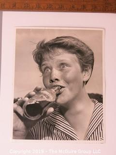 Photo: Historical; Americana: Golf: Identified expressive girl drinking soda